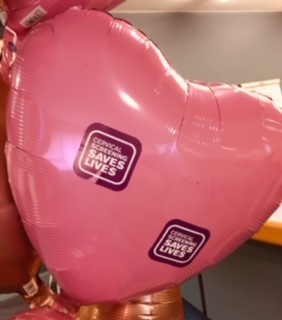 pink shaped heart ballon with stickers that say cervical screening saves lives